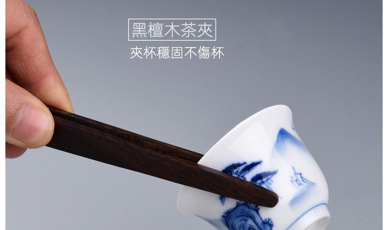 黑檀木茶道六君子，南山居黑檀木茶夾，夾持青花山水紋茶杯，紋理細膩，穩固不傷杯，展現茶道配件的精緻。
