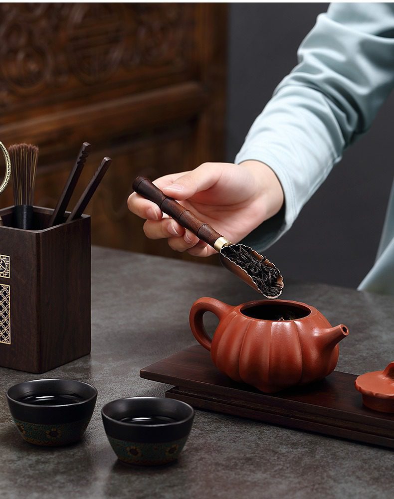 黑檀木茶道六君子，南山居紫砂南瓜壺，壺身飽滿圓潤，搭配木質茶匙將精選茶葉緩緩入壺，展現專業茶道。