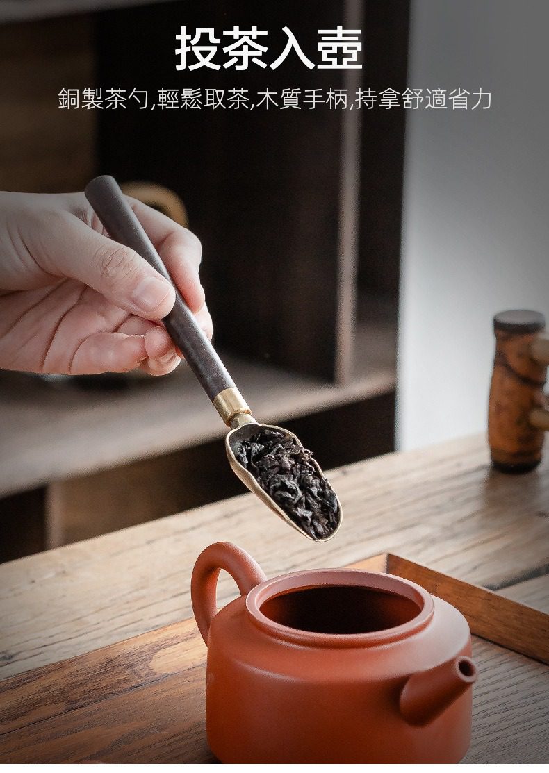 黑檀木茶道六君子，南山居銅木茶勺，勺中盛滿烏龍茶葉，準備投入溫潤紫砂壺中，彰顯優雅茶道配件。