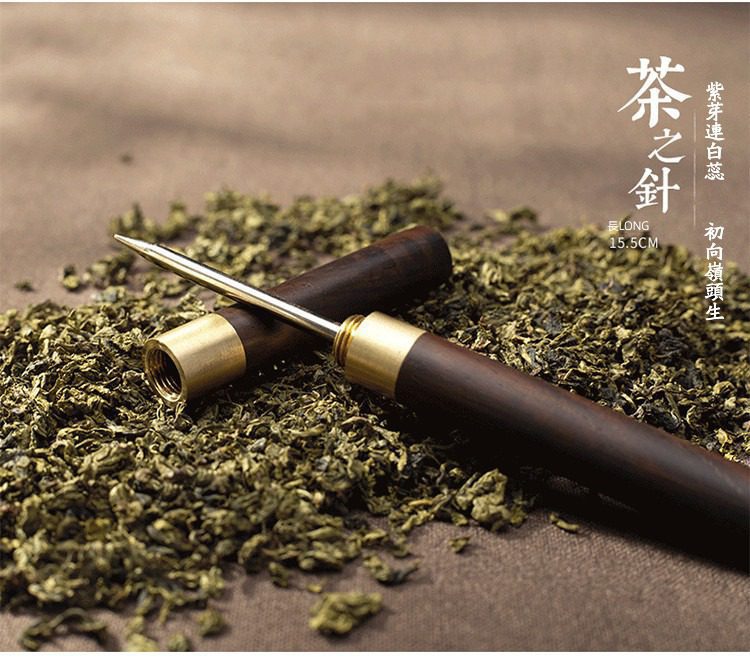 黑檀茶道六君子，南山居精品黑檀木黃銅茶針，尖銳金屬頭與螺紋設計，置於青綠茶葉堆中，專業開茶器。