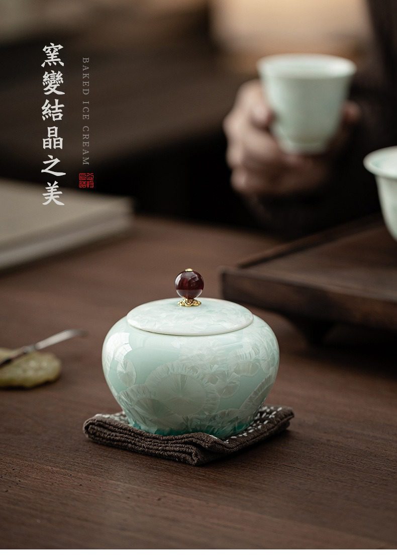 窯變結晶青綠圓肚茶葉罐，南山居窯變結晶茶葉罐，淺青色釉面綻放獨特結晶花紋，搭配紅色寶珠鈕。