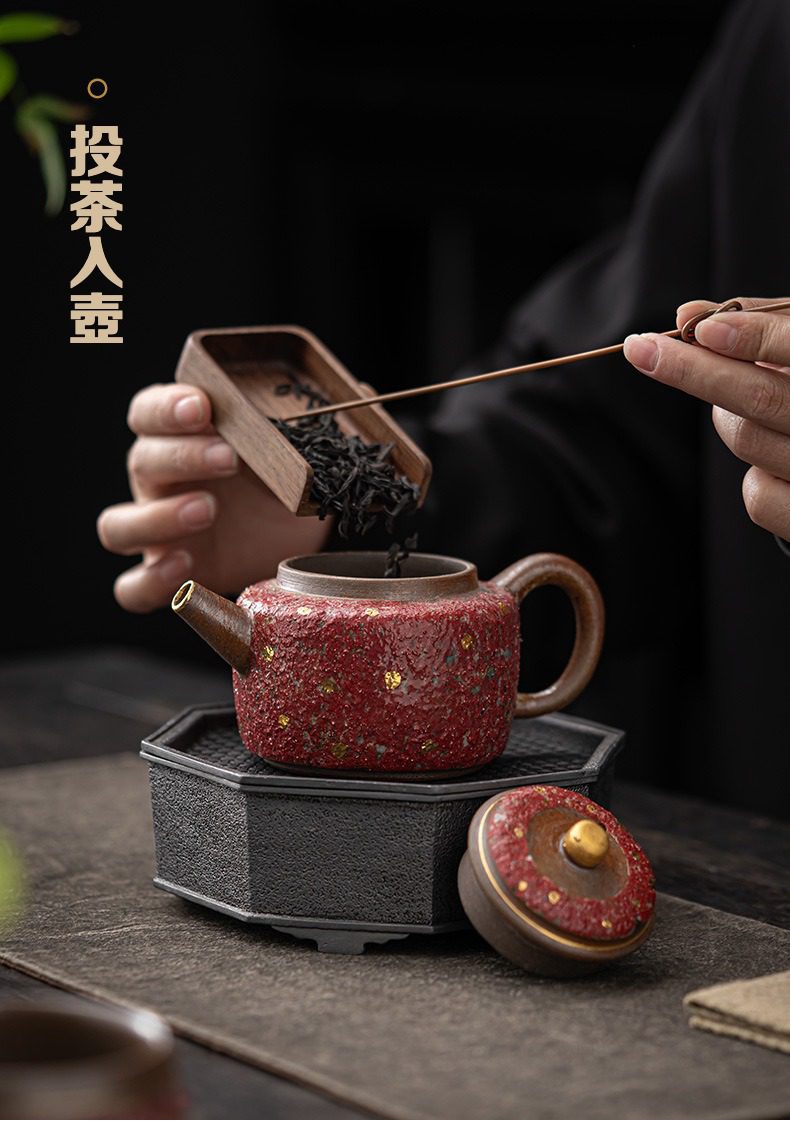 岩礦德鐘壺，南山居手工赤金點粗陶茶壺，壺身滿綴金點，搭配木質茶則與茶匙，展現專業奉茶之美。