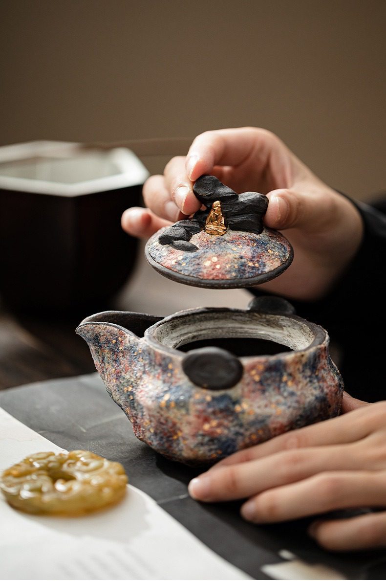 岩礦手抓壺，南山居手工禪意茶壺，壺蓋飾金色佛陀與岩石，壺身斑斕釉色獨特，體現藝術茶具。