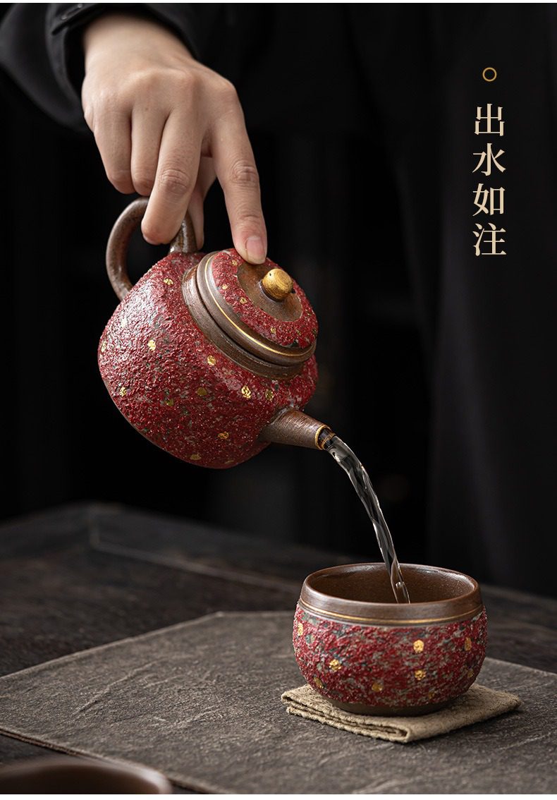 岩礦德鐘壺，南山居手工粗陶茶具組，壺身與茶杯皆為斑駁紅泥質感，綴以金點，展現手工茶具的古樸雅韻。