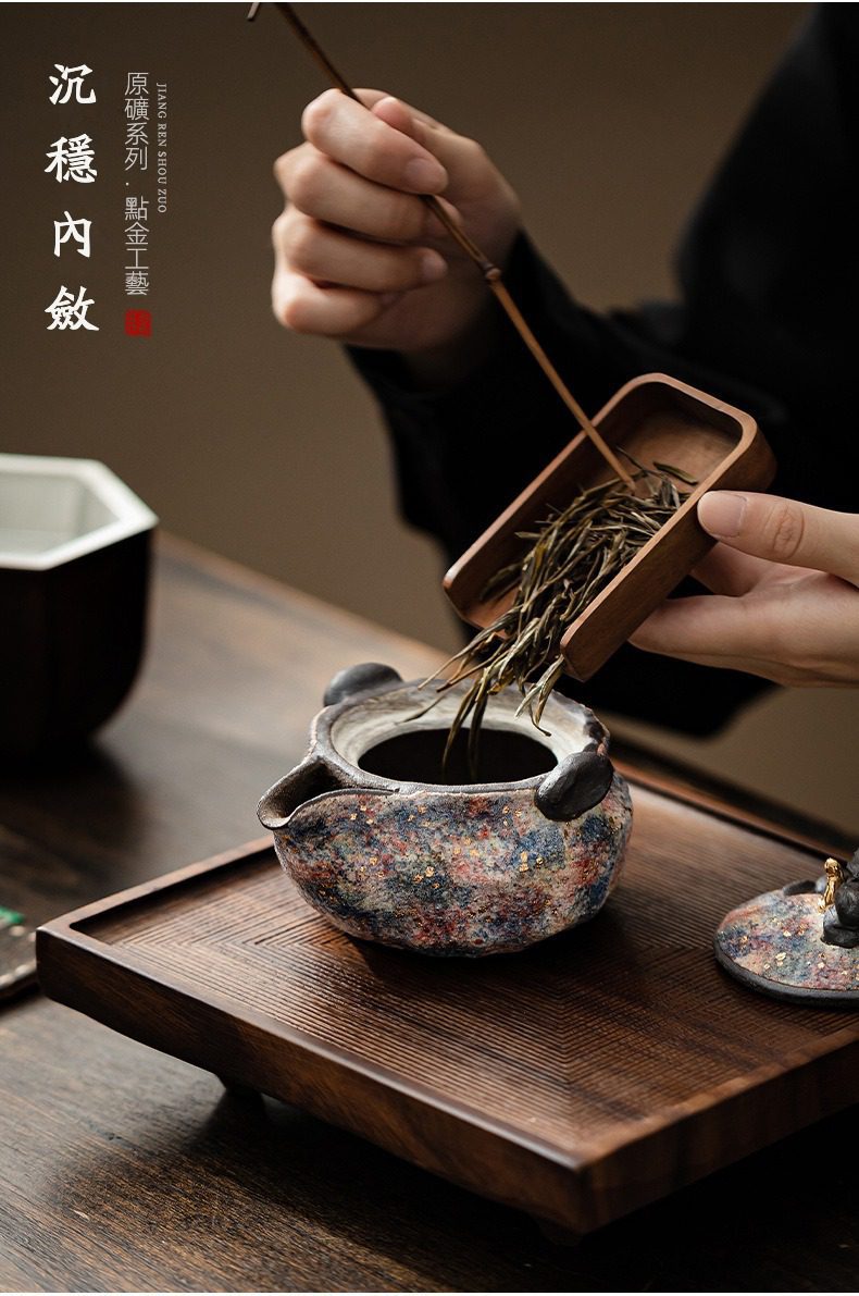 岩礦手抓壺，南山居手工原礦點金茶壺，斑斕釉色點綴金光，茶師以竹茶則置茶，展現茶道專業與優雅。