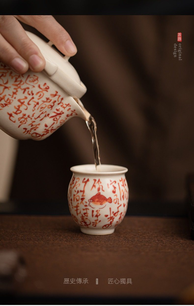 百圾碎蘇打釉品茗杯，南山居手繪陶瓷公道杯與茶杯，杯身皆有紅色書寫文字與可愛小金魚圖案，茶湯入杯，雅緻非凡。