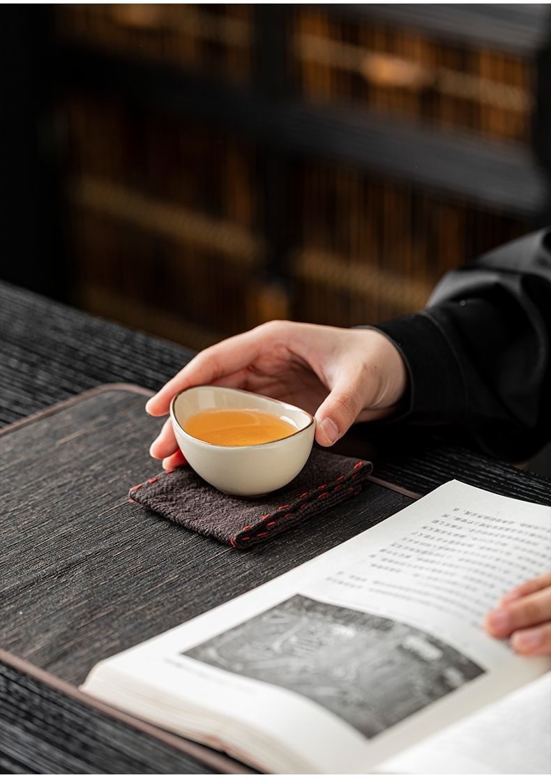 汝窯元寶品茗杯，南山居手工溫潤陶瓷品茗杯，盛裝琥珀色茶湯，展現優雅茶道氛圍