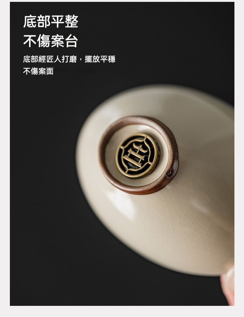 汝窯元寶品茗杯，南山居高品質陶瓷茶杯底部特寫，米白色開片釉面細膩，搭配匠心打磨平穩底座與品牌金屬標識，展現茶具精緻工藝。