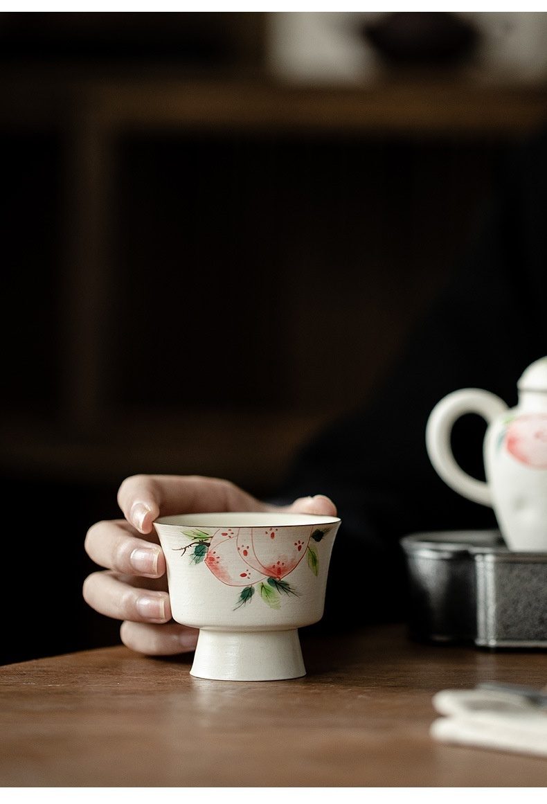 粉引 - 手繪壽桃品茗杯，南山居手繪壽桃高足茶杯，陶瓷質地溫潤，杯身彩繪雅致桃子圖案，口沿描金邊。
