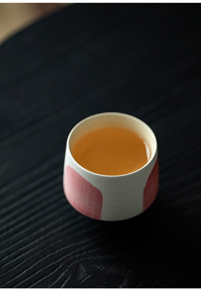 粉引白 - 水抹粉品茗杯，南山居手工藝術陶瓷茶杯，杯身潔白飾以優雅粉色紋路，盛裝琥珀色茶湯，展現獨特茶席美學。