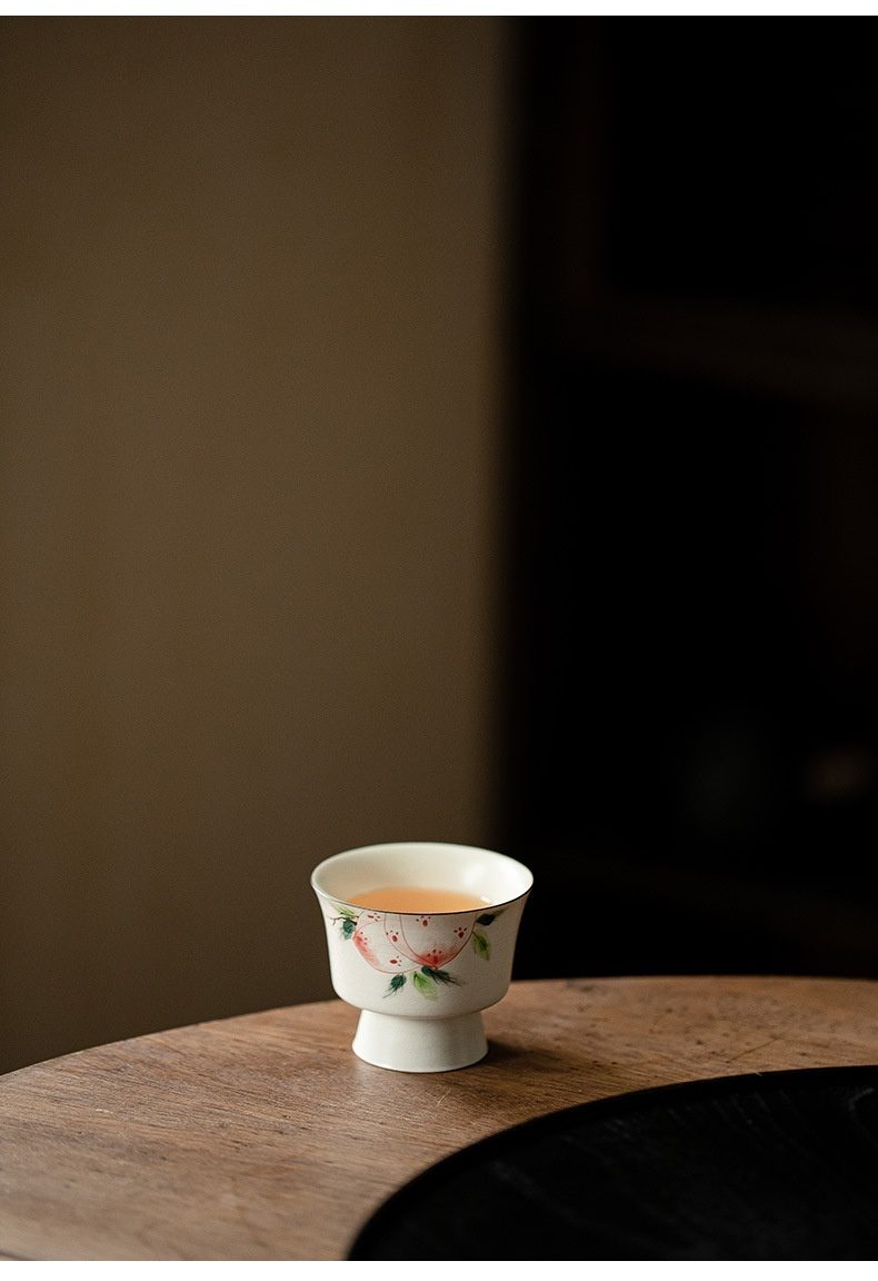 粉引 - 手繪壽桃品茗杯，南山居精緻陶瓷高足品茗杯，杯身手繪淡雅蜜桃圖案，盛裝金黃茶湯，盡顯茶道雅韻。