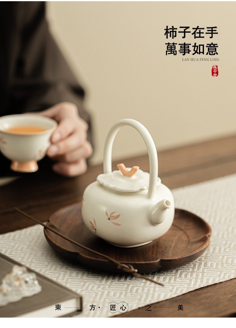 米黃定窯蘭花風鈴提樑壺，南山居手工陶瓷提樑壺，壺身溫潤潔白，飾以手繪柿子花紋與柿子壺鈕，展現典雅東方茶具美學。