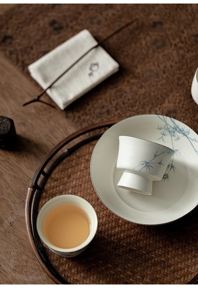 粉引白 - 手繪墨竹品茗杯，南山居雅緻青花竹紋陶瓷品茗杯與茶托，搭配溫潤竹編茶盤，盡顯茶道之美。
