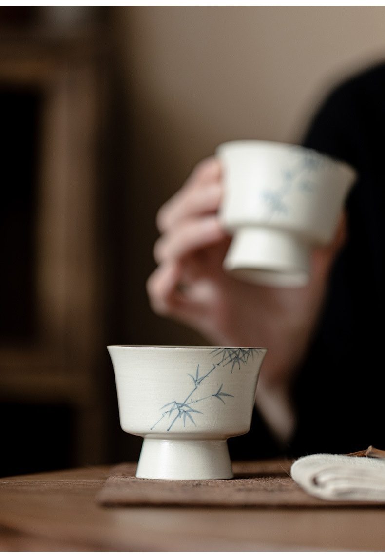 粉引白 - 手繪墨竹品茗杯，南山居手繪青竹陶瓷高足品茗杯，米白色杯身點綴藍色竹葉，盡顯禪意茶具之美。
