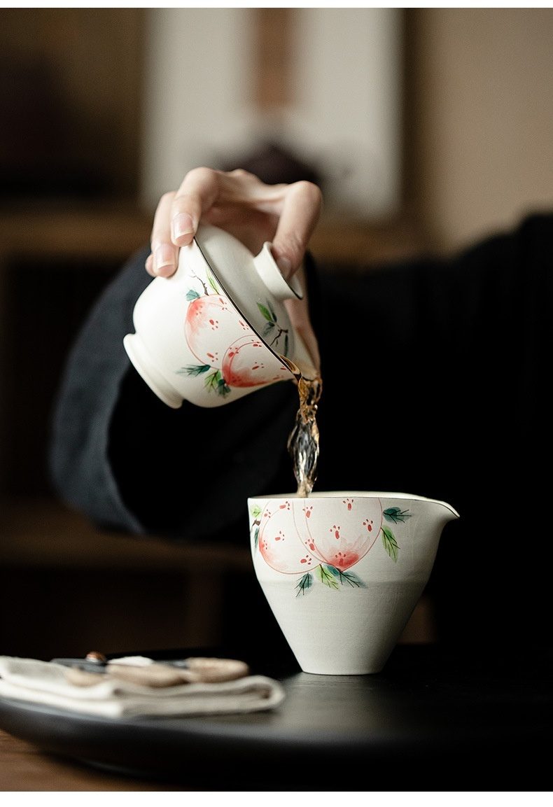 粉引 - 手繪壽桃公道杯，南山居手繪桃子圖案白瓷蓋碗與公道杯，茶湯正從蓋碗流向公道杯，優雅茶席。