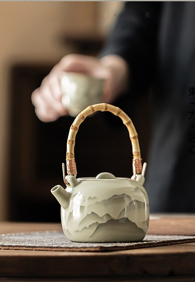 仿古汝窯山山如花提樑壺，南山居手工青瓷山水提梁壺，竹製提梁纏繞銅線，壺身繪有淡雅山景，盡顯禪意茶道美學。