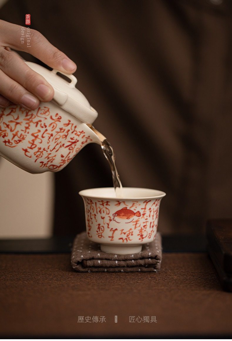 百圾碎蘇打釉品茗杯，南山居手繪錦鯉白瓷茶杯，搭配朱紅書法紋飾手沖茶壺，茶湯緩緩入杯，展現茶道美學。