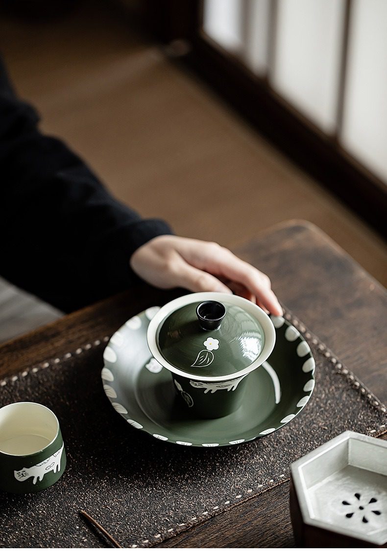 粉引橄欖綠 - 手繪貓蓋碗，南山居墨綠色陶瓷蓋碗茶具，飾以手工白貓與花葉紋樣，營造優雅禪意品茗氛圍。