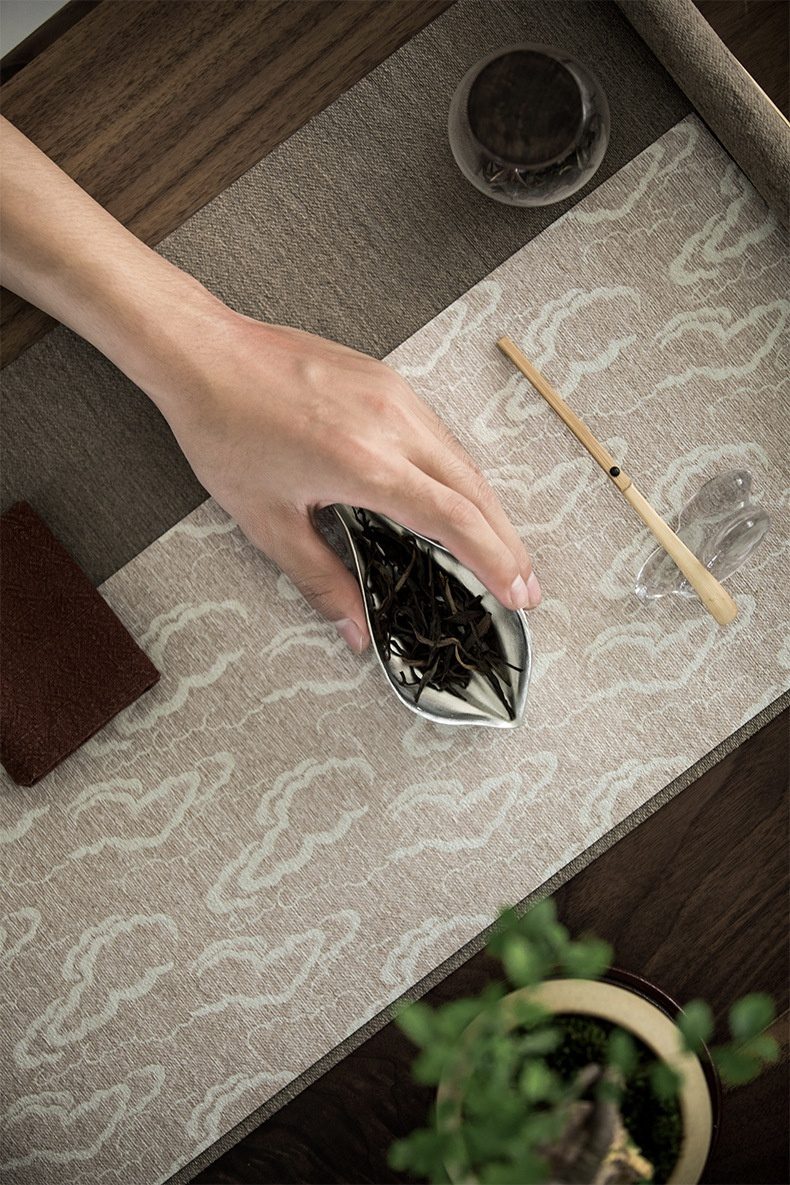 禪意手工錫蓮瓣茶則，南山居金屬茶則盛裝烏龍茶葉，手部優雅展示品茗準備，搭配雅緻茶席，展現茶道美學。