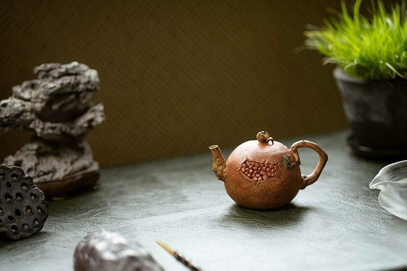 宜興紫砂壺原礦降坡泥石榴仿生壺(180ml)，南山居手工紫砂石榴壺，壺身圓潤飽滿，泥繪石榴果實細膩生動，流把彎曲如枝，古樸雅致。