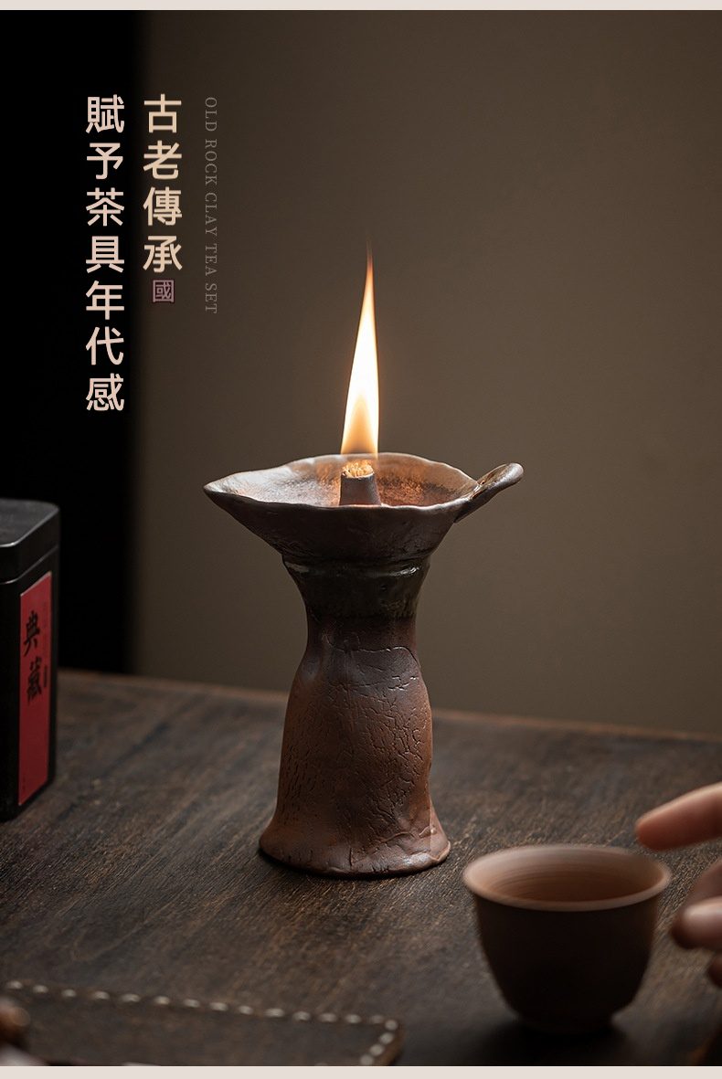 老岩泥粗陶燭台，南山居手工老岩泥香薰爐，粗獷原礦質感，搭配溫暖燭光營造禪意茶席氛圍，旁邊擺放古樸茶杯。