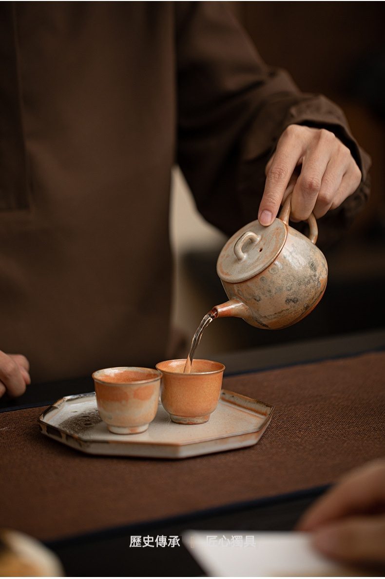 志野燒窯變古瓦壺，南山居手工柴燒陶壺與品茗杯，壺身斑駁沉靜，茶湯緩緩注入杯中，展現茶道日常