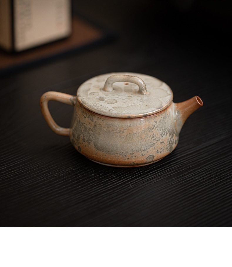 志野燒窯變古瓦壺，南山居手作粗陶茶壺，壺身扁圓樸拙，釉色自然斑駁，盡顯侘寂之美。