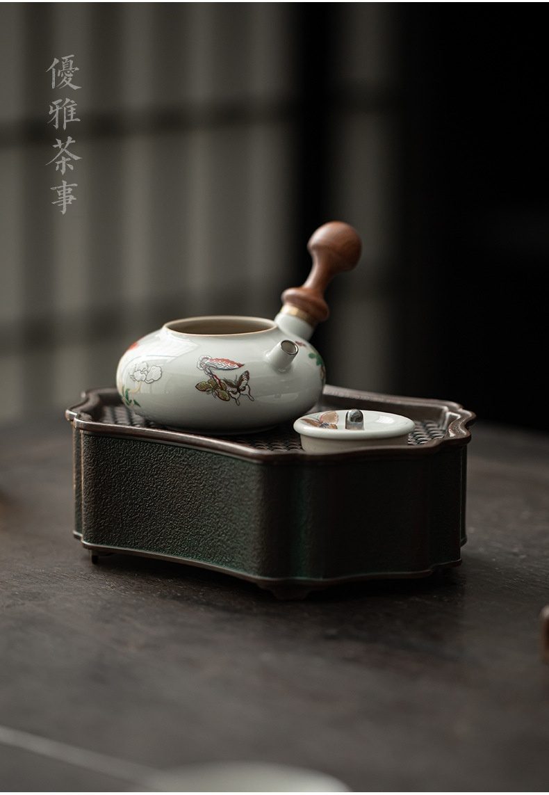 三味茶品 - 月蝶側把小品壺，南山居手繪瓷器橫把壺，壺身潔白飾彩蝶花卉圖案，搭配溫潤木質把手，置於茶盤上。