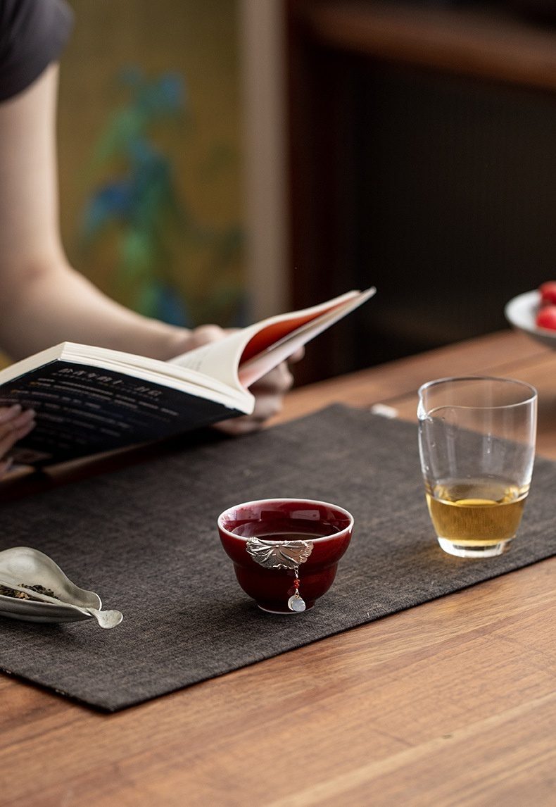 郎紅鑲銀蝴蝶荷韻品茗杯，南山居手工赤釉品茗杯，深紅釉色溫潤，杯身點綴精緻銀葉吊墜，展現禪意茶道美學。