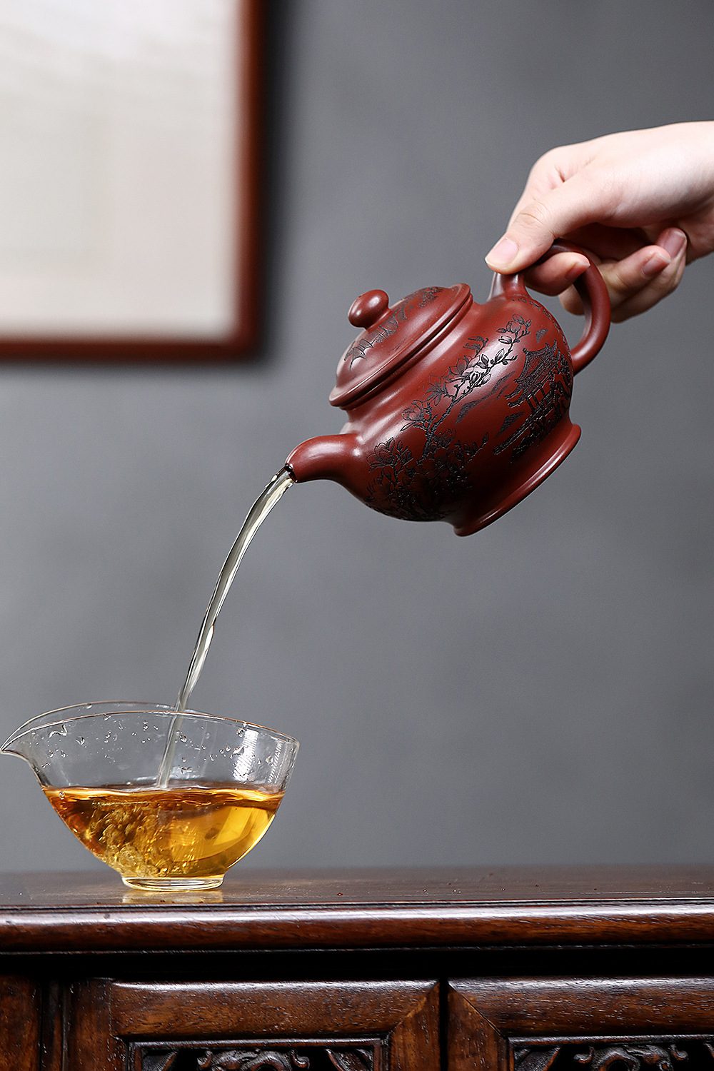 宜興紫砂壺原礦龍血砂玉蘭掇只壺(360ml)，南山居精緻紫砂壺，壺身呈紅褐色，刻繪傳統山水與花卉圖案，出水流暢，展現茶道藝術之美。