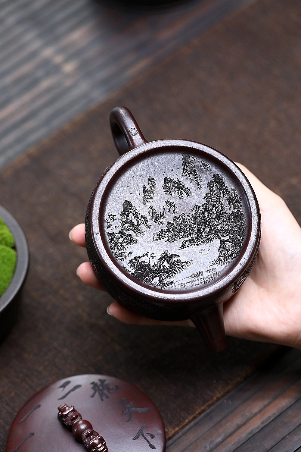 宜興紫砂壺原礦鐵血紅砂雙龍戲珠壺(250ml)，南山居珍藏級紫砂壺，壺底精緻山水刻繪，深沉泥色蘊含自然禪意。