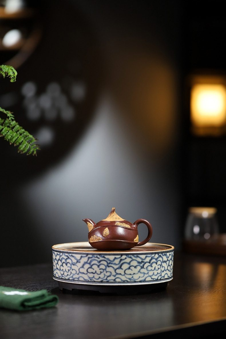 宜興紫砂壺原礦紫泥荸薺仿生壺(100ml)，南山居手工紫砂壺與祥雲茶盤組合，壺身深邃紅褐，飾以金沙山形紋，搭配青花祥雲茶盤，彰顯禪意。