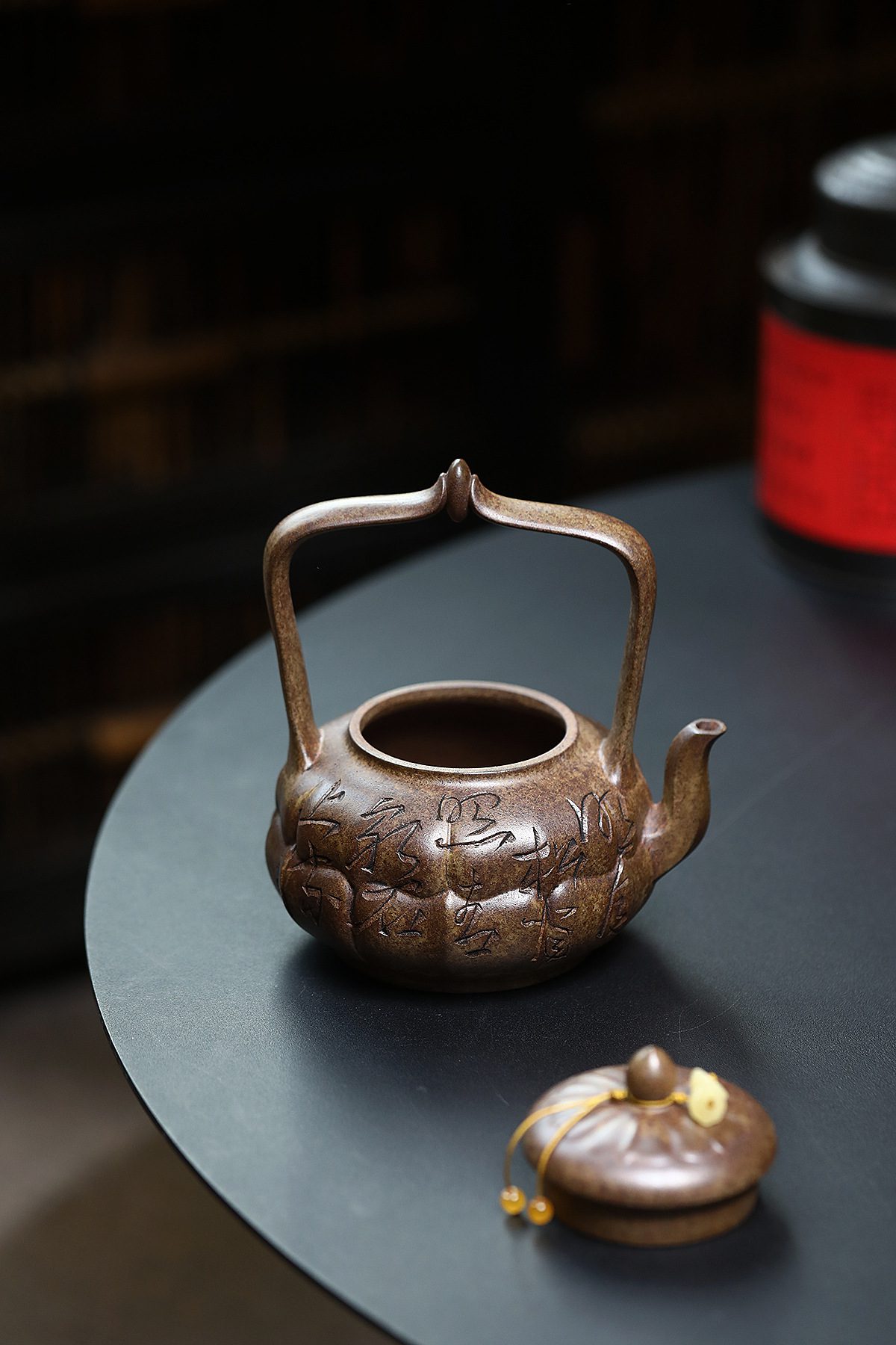 宜興紫砂壺原礦沉香泥筋紋焚蓮提梁壺(420ml),南山居手工段泥提樑壺,壺身雕刻古樸紋飾與文字,高提把設計優雅,展現獨特茶道美學。