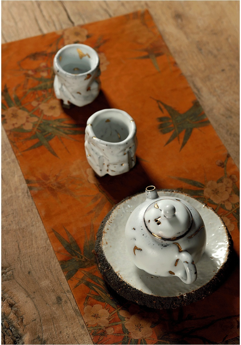 志野燒雲古茶壺，南山居手工金繕風陶瓷茶壺與茶杯組，器型不規則且點綴優雅金箔，置於精美茶席上。