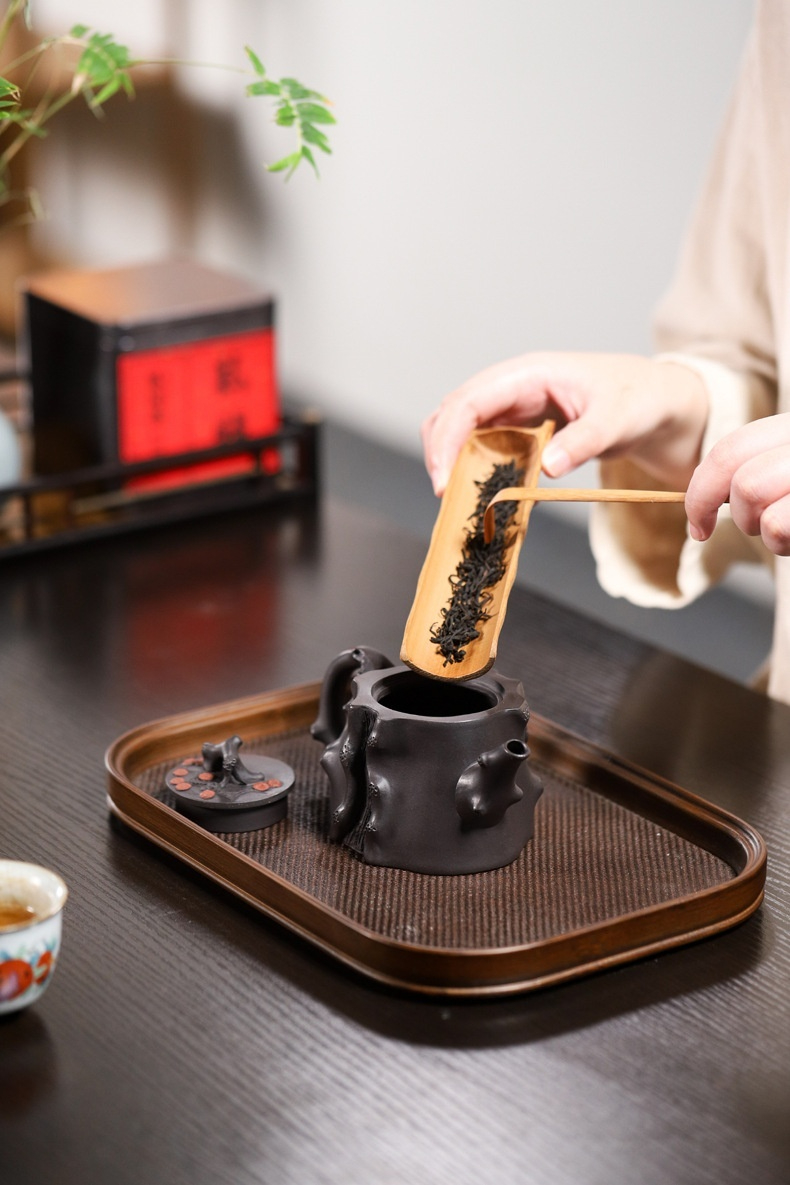 宜興紫砂壺原礦高黑泥松樁茶壺(270ml)，南山居手工仿樹樁紫砂壺，壺身雕塑粗獷自然，搭配竹製茶則將茶葉輕柔撥入，展現茶道美學。