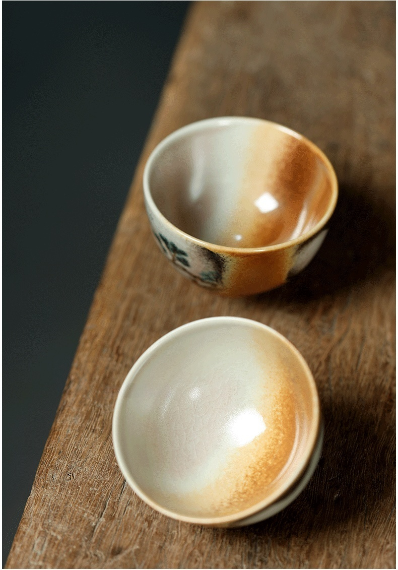 志野燒手繪山水品茗杯，南山居手工陶瓷品茗杯，器身採用漸變釉色，結合樸拙的泥繪與細膩的裂紋釉，展現獨特的禪意茶道美學。