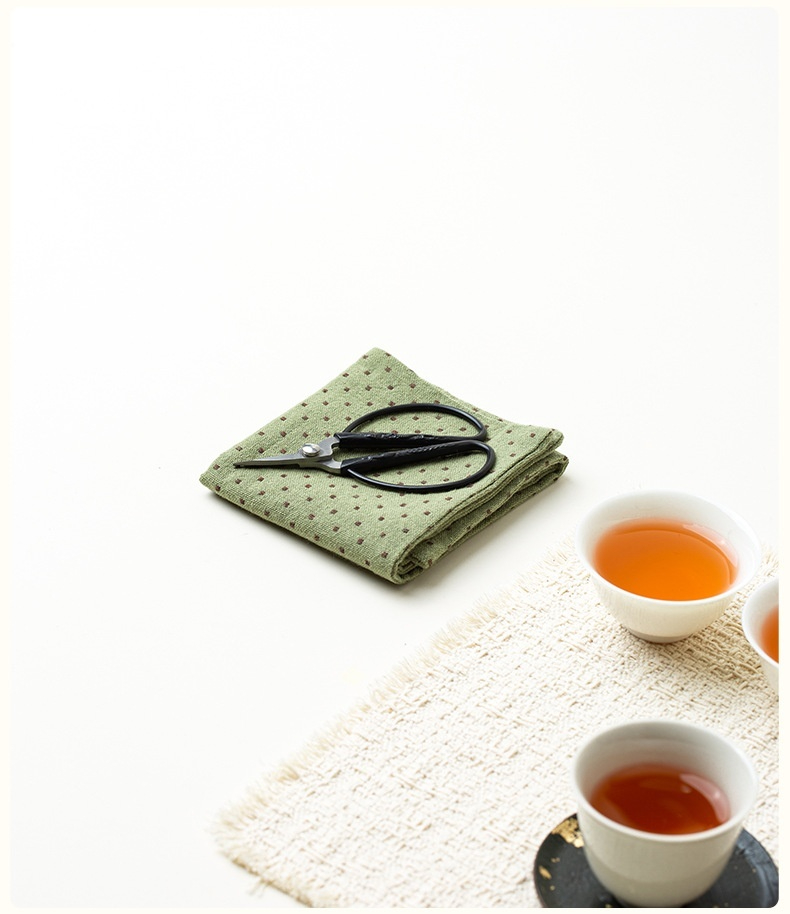 小波點 － 棉麻吸水茶巾，南山居茶席上的專業茶剪與點點茶布，搭配溫潤茶湯的茶杯與棉麻茶墊，展現靜謐茶道氛圍。