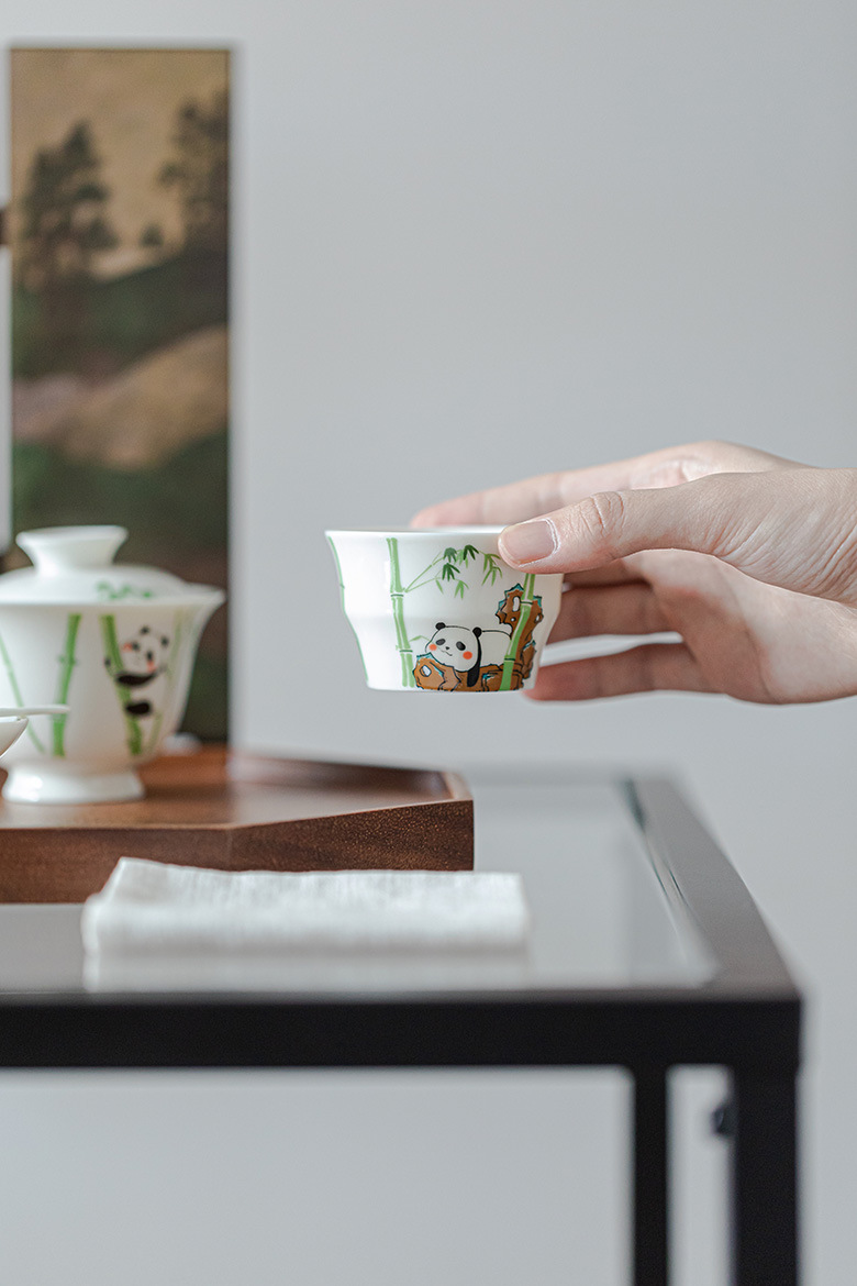 玉泥白瓷 － 竹節杯，南山居陶瓷功夫茶杯，白瓷胎體繪有可愛熊貓與青竹圖案，展現童趣與禪意。