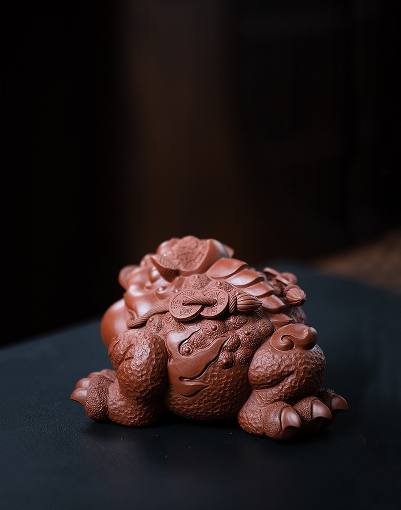 宜興原礦大紅袍將軍蟾茶寵，南山居紫砂金蟾茶寵，招財三足蟾蜍，身背古幣元寶，泥色溫潤，雕工精緻，為茶席增添雅趣。