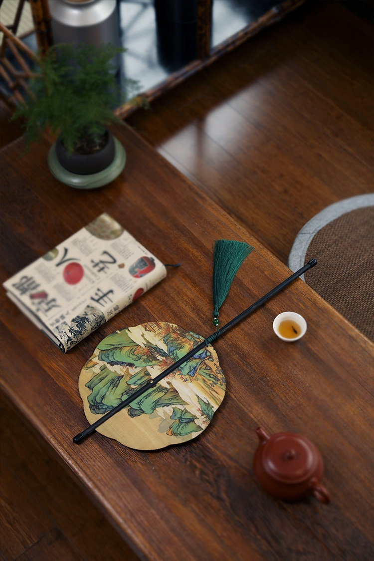 古畫竹絲腰扇，南山居溫潤朱泥小品紫砂壺與精緻白瓷品茗杯，佐以古典山水團扇，營造靜謐茶席美學。