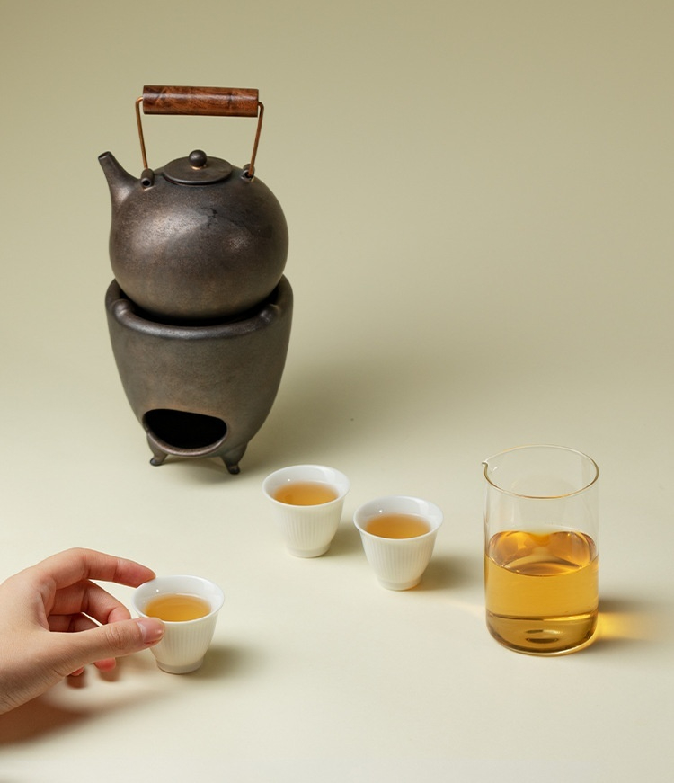 圍爐煮茶 － 入松歸野提梁壺溫茶爐套組，南山居鑄鐵提梁壺溫茶組，配雅緻白瓷杯、玻璃公道杯，展現專業茶道美學。