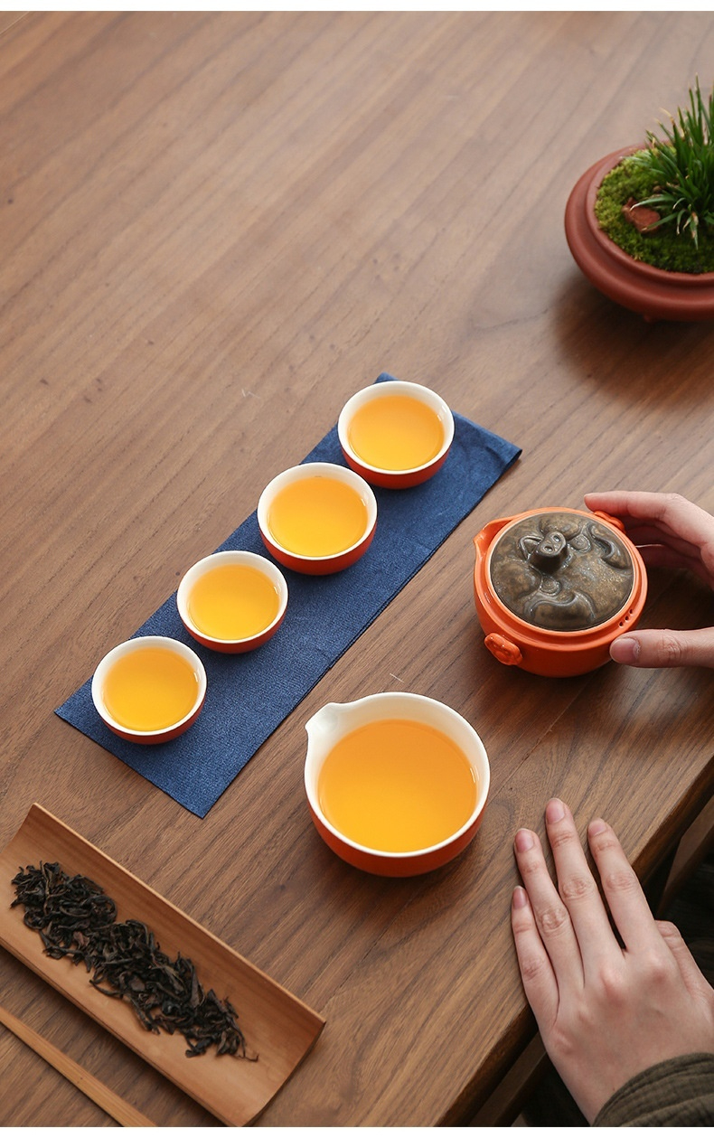 豬柿順遂快客杯，南山居手工紫砂壺搭配橙色品茗杯與公道杯，茶湯色澤金黃，展現優雅茶道美學。