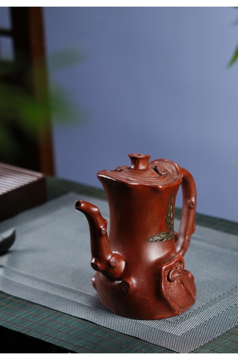 宜興紫砂壺原礦紅泥高樹樁仿生壺(720ml)，南山居手工紫砂樹樁壺，紅褐色泥質溫潤，壺嘴壺把仿樹枝造型，壺身飾有精緻葉片浮雕，展現茶道藝術。