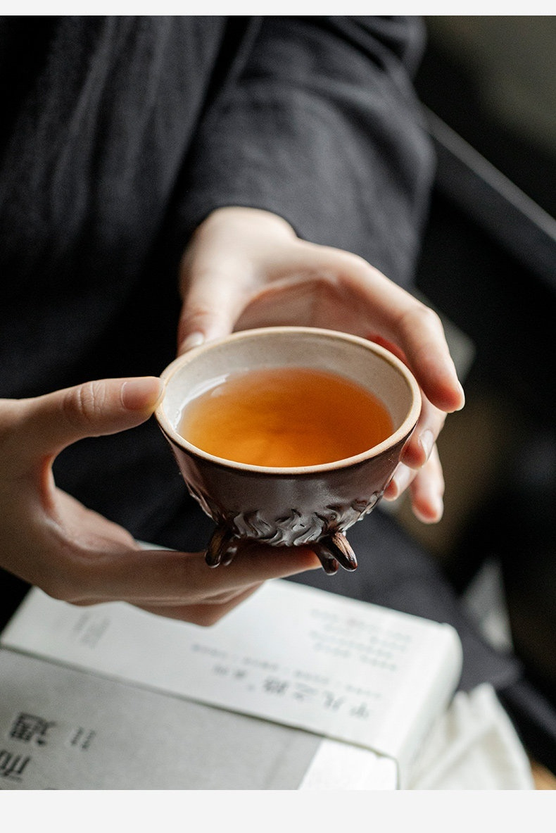 柴燒龍蛇主人杯，南山居手工三足茶杯，粗陶紋理結合三足設計，盛載金黃茶湯，盡顯禪意茶道美學。
