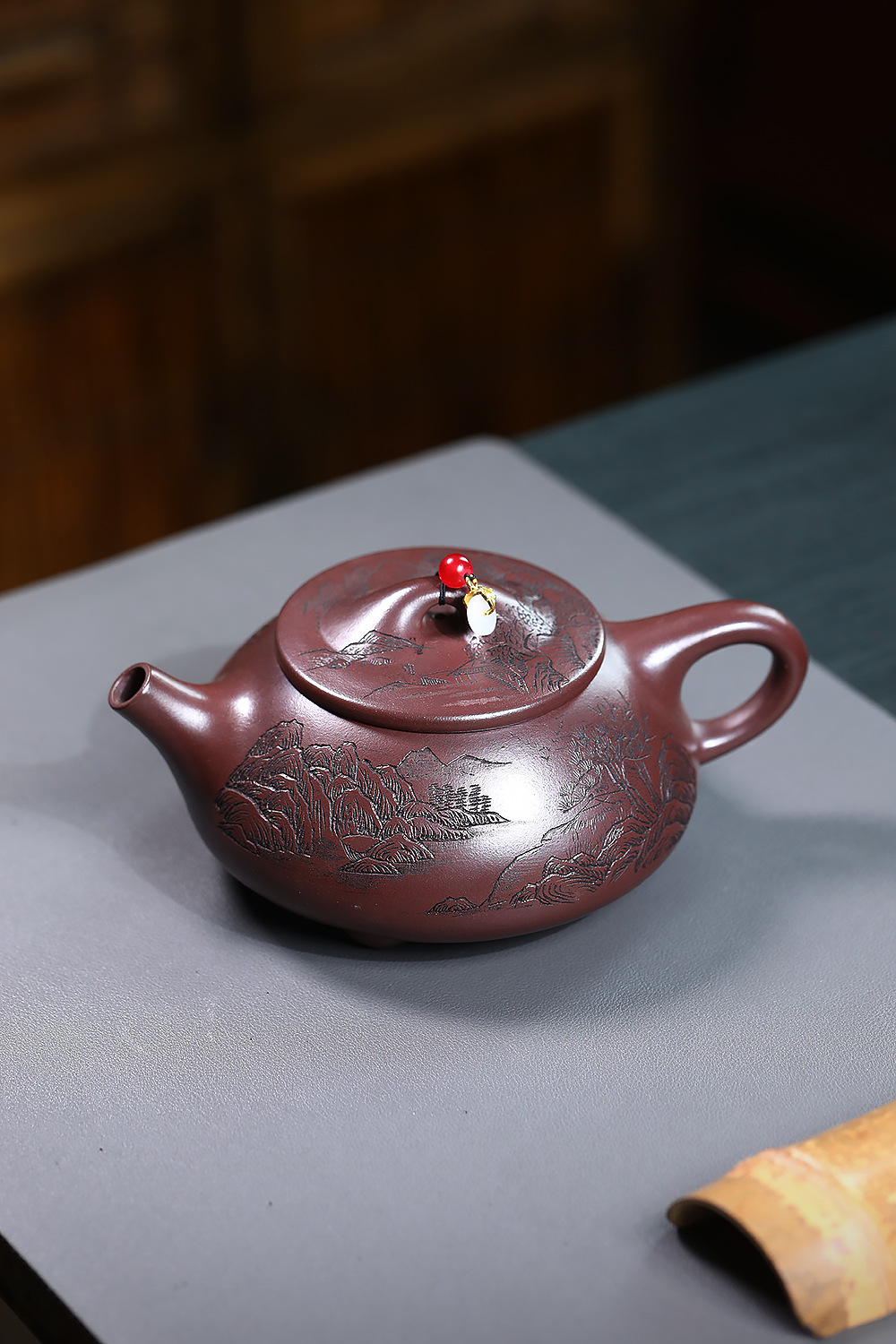 宜興紫砂壺原礦紫泥山水石瓢壺(460ml)，南山居手工紫砂壺，壺身雕刻精緻山水圖案，泥色溫潤典雅，壺蓋飾有珠串，彰顯東方茶道美學。