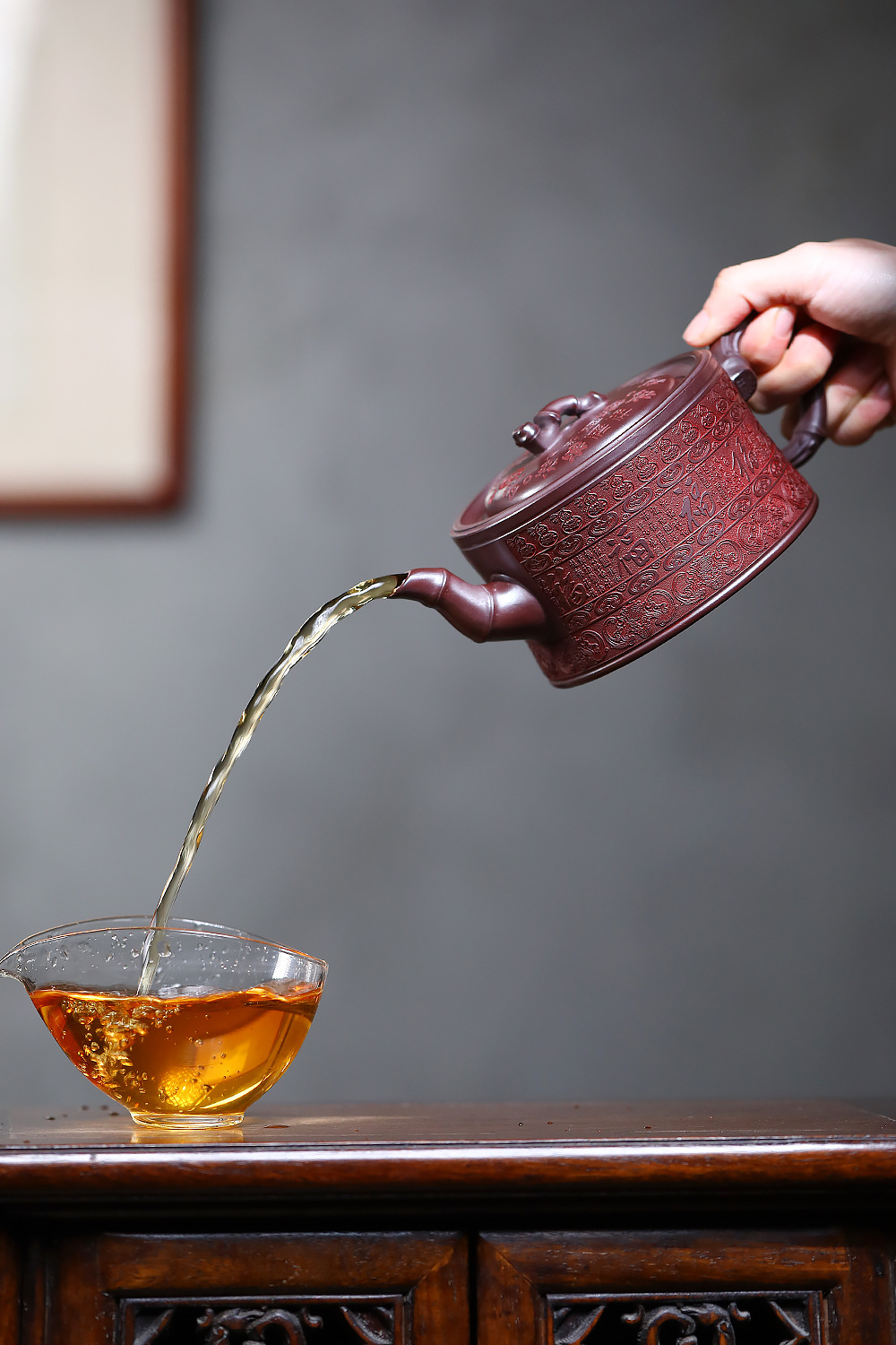 宜興紫砂壺原礦石紅泥百福竹節壺(480ml)，南山居手工刻繪紫砂壺，壺身滿刻吉祥紋飾，將金黃茶湯傾注入透明玻璃公道杯，展現專業茶道美學。