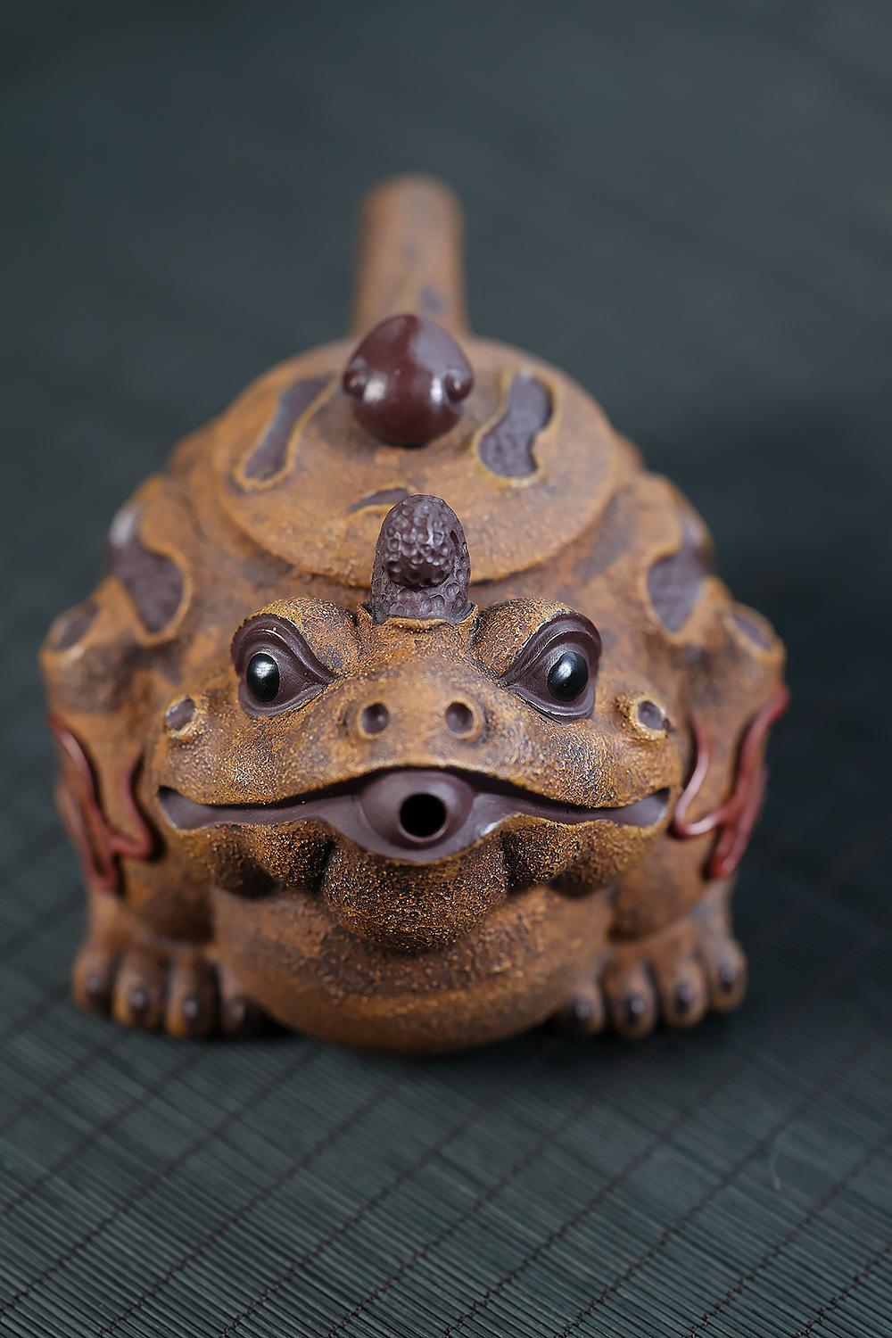 宜興紫砂壺原礦紫泥段泥金蟾吐納仿生壺(170ml)，南山居紫砂金蟾壺，手工雕琢仿古泥色，蟾蜍造型生動傳神，口部作壺嘴，獨具創意，是茶席上的藝術品。
