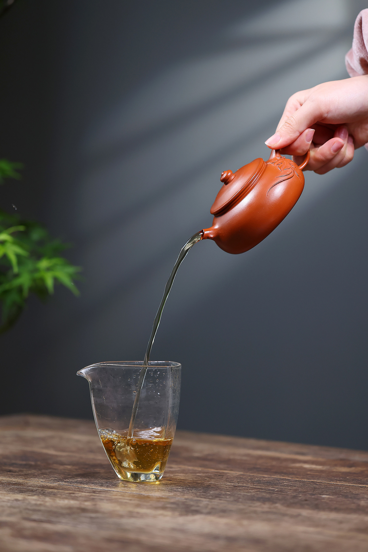 宜興紫砂壺原礦朱泥知秋寒江壺(180ml)，南山居手工朱泥紫砂壺將金黃茶湯緩緩注入晶瑩剔透的玻璃公道杯中，展現優雅茶道流程。