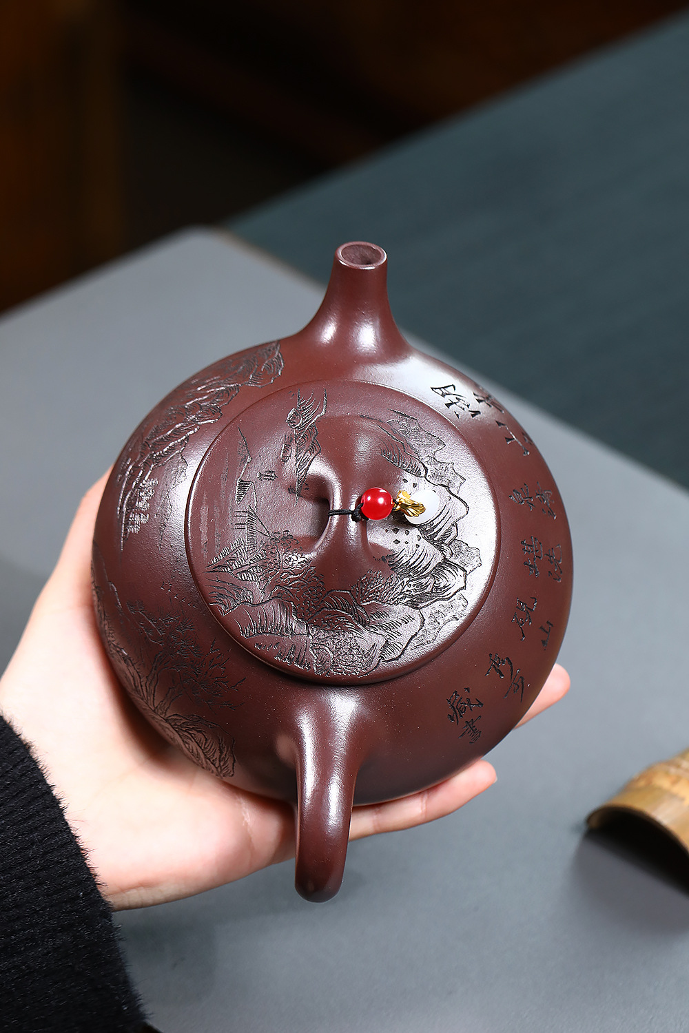 宜興紫砂壺原礦紫泥山水石瓢壺(460ml)，南山居手工紫砂刻繪扁壺，壺身浮雕精緻山水紋飾與書法，搭配獨特紅珠壺鈕，展現典雅茶藝。