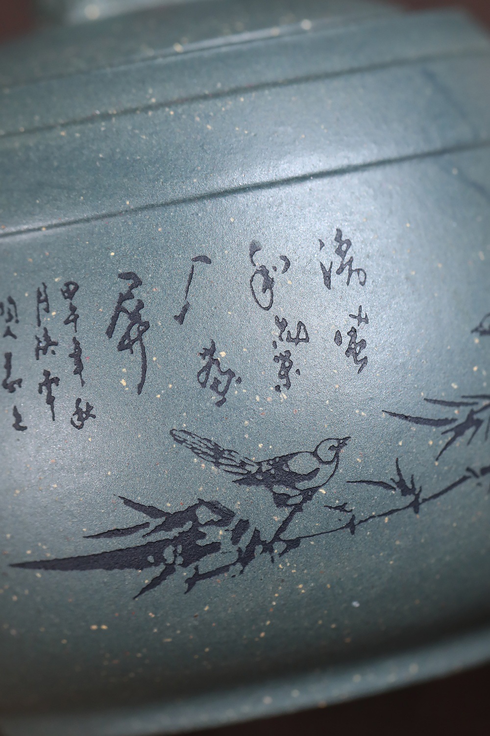 宜興紫砂壺原礦天青泥天青雄獅壺(320ml)，南山居手工紫砂茶壺，壺身呈現雅緻墨綠色，雕刻有詩文、竹葉與飛鳥，質感細膩。